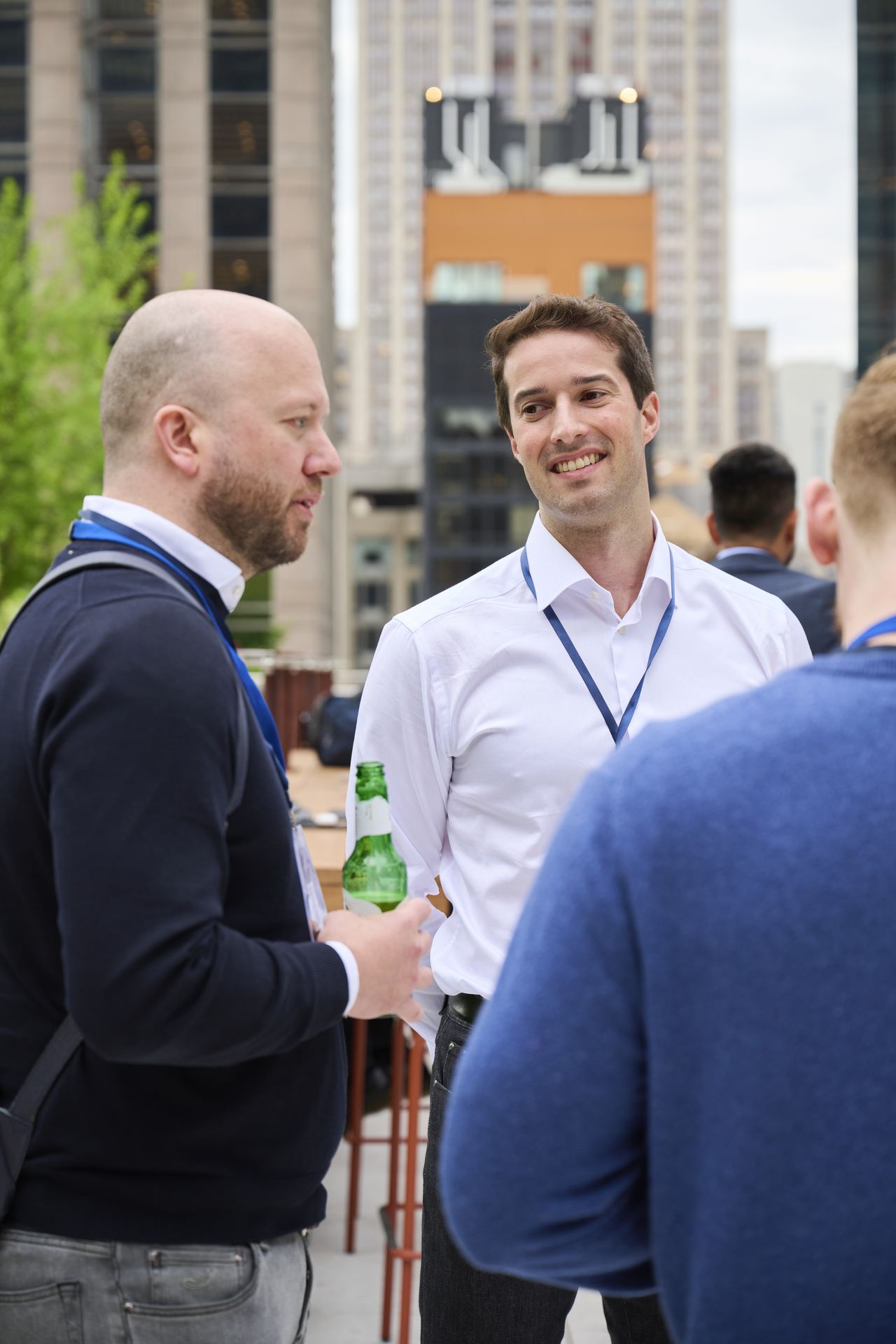 Two attendees in conversation on the rooftop